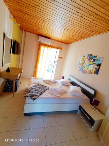 a large bed in a bedroom with a wooden ceiling at Spasmata Village- Adults Only Houses Full Sea View Near Beach Quiet Escape in Minia