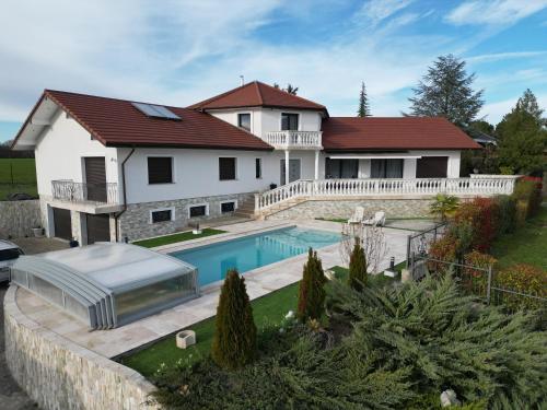 une maison avec une piscine dans une cour dans l'établissement Villa 5*, 15 personnes, Piscine à 20 min de Genève, à Juvigny
