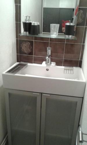 un lavabo blanc dans une salle de bain avec un miroir dans l'établissement Saint-Mandrier ou la presqu'île de beauté, à Saint-Mandrier-sur-Mer