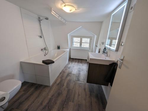 a bathroom with a tub and a sink and a toilet at Residenz Vier Jahreszeiten Monschau in Monschau