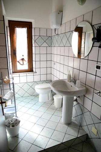 a bathroom with a sink and a toilet and a mirror at Agriturismo Sa Perda Marcada in Arbus