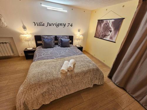 una camera da letto con un letto con due pantofole sopra di Villa 5*, 15 personnes, Piscine à 20 min de Genève a Juvigny