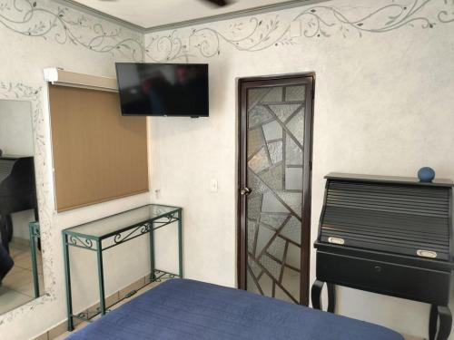 a bedroom with a bed and a tv on the wall at HOTEL CASA LIMON in Santa Rosa de Jáuregui