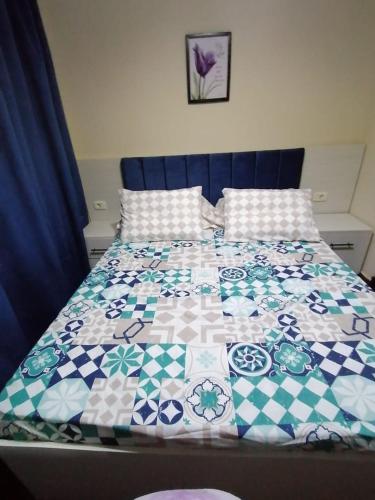 a bed with a blue and white quilt on it at شقة فندقية في شرم الشيخ in Sharm El Sheikh