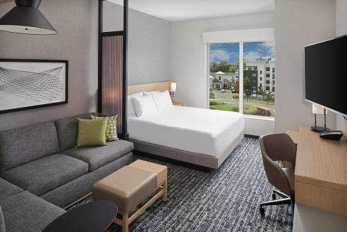 a hotel room with a bed and a couch at Hyatt Place Murfreesboro in Murfreesboro