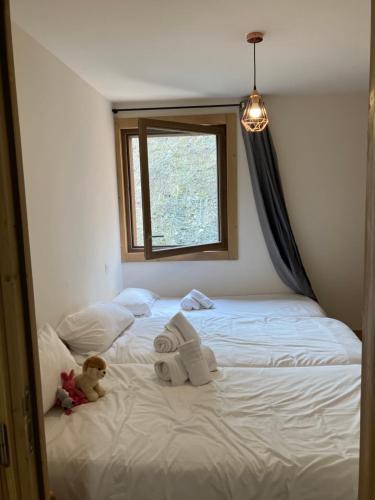 a bed with towels and a teddy bear sitting on it at Luxurious duplex for 4-7p with large terrace and pool in ski-in ski-out 5 star residence at Les Arcs in Bourg-Saint-Maurice