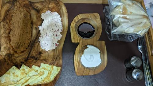 una tabla de cortar de madera con un plato de comida y patatas fritas en A&S House en Siwa
