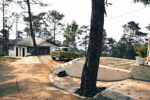 a van parked in a driveway next to a tree at ROYALTY GLOBAL HOMESTAY in Shillong
