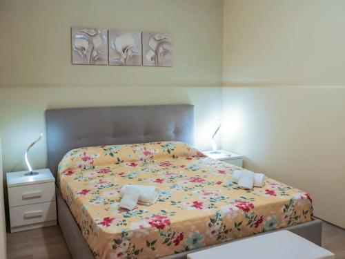 een slaapkamer met een bed met bloemen erop bij Casa Vacanze Michelangelo in Letojanni
