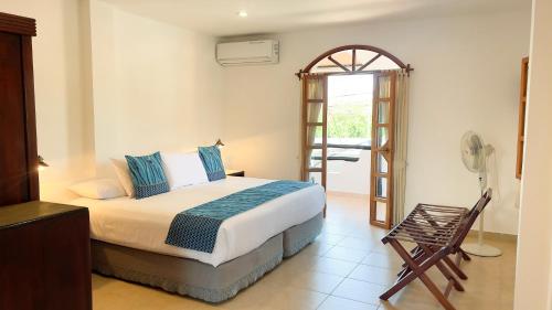 um quarto com uma cama e uma cadeira em Hotel Galapagos Suites B&B em Puerto Ayora