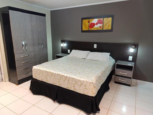 um quarto com uma cama grande e duas mesas de cabeceira em Altos del Iguazu em Porto Iguaçu