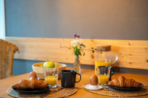una mesa de madera con huevos y cruasanes. en Feriemhof Kruse Wohnung Nr 1, en Grömitz