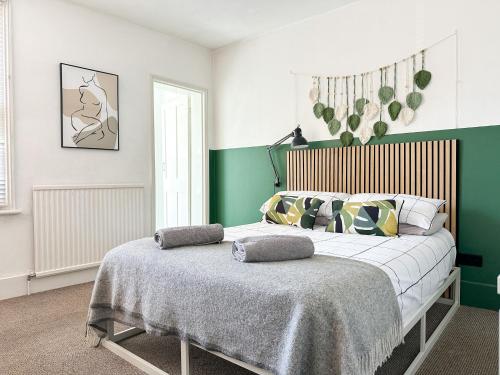 een slaapkamer met een groot bed met groen en wit bij Love Lane - Cosy & Modern City Centre Guest Suite in Canterbury