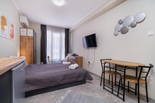 a small bedroom with a bed and a table at City Center Studio Apartments in Plovdiv