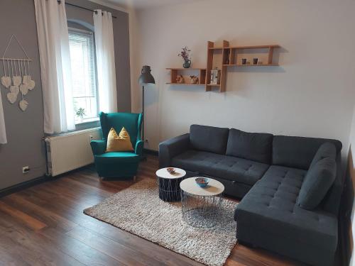 uma sala de estar com um sofá azul e duas cadeiras em Ferienwohnung am Windberg em Freital