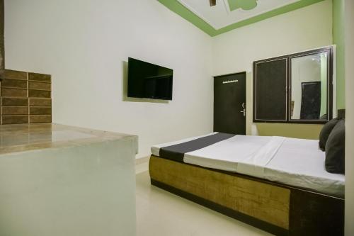 - une chambre avec un lit et une télévision à écran plat dans l'établissement OYO NAZ GUEST HOUSE, à Jalandhar