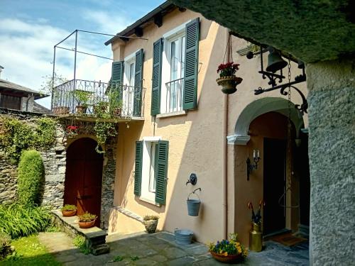a house with green shuttered windows and a balcony at Casa Longhi in Orta San Giulio