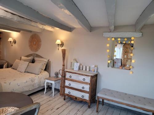 a bedroom with a bed and a dresser and a mirror at Le Clos Des Etoiles in Le Bugue