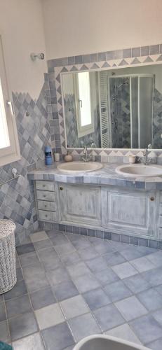 a bathroom with two sinks and a large mirror at Villa Baja Sardinia in Baja Sardinia