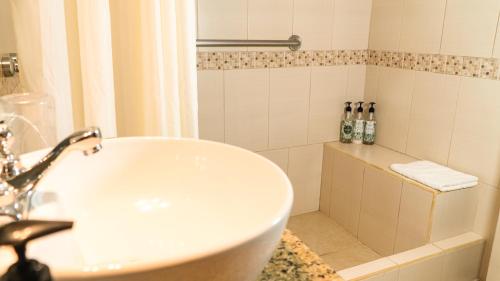 a bathroom with a white sink and a shower at Hotel Galapagos Suites B&B in Puerto Ayora