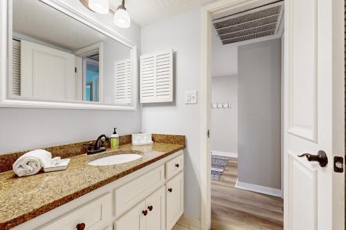 uma casa de banho com um lavatório e um espelho em 2023 Beach Wood em Fernandina Beach