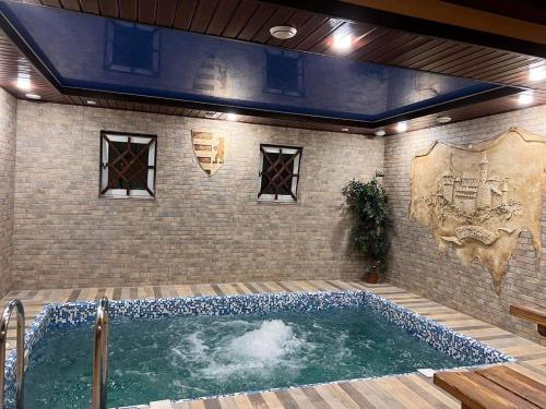 a hot tub in a room with a brick wall at Polyanskiy Zamok in Polyana
