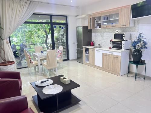City Park Residence في كونستانتا: غرفة معيشة مع مطبخ وغرفة طعام