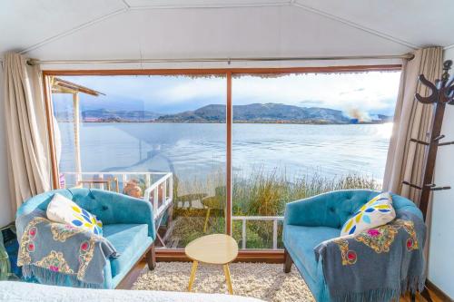 a room with two chairs and a view of the water at Titicaca Uros Summa Paqari in Uros