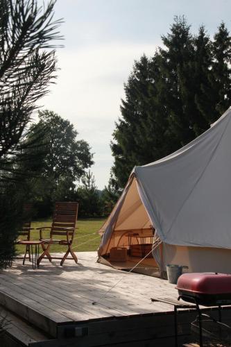 a tent and a chair on a wooden deck at Casa de campo glamping in Eželiškės