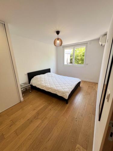 - une chambre avec un lit et une fenêtre sur du parquet dans l'établissement CosyT2 Lumineux, à Deux Pas du Vélodrome, à Marseille