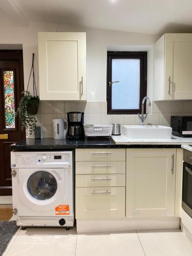 a kitchen with a washing machine and a sink at Tower Bridge Studios in London