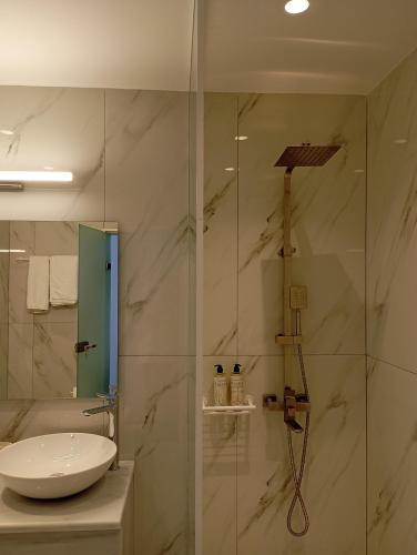 a bathroom with a sink and a glass shower at Ifestia Hotel in Kamari