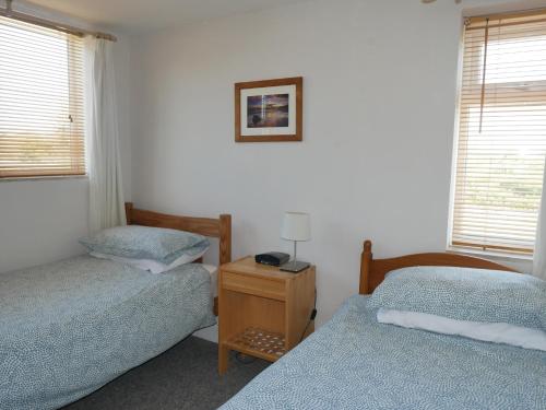 a bedroom with two beds and a table with a lamp at Fisherman's Cottage in Portland