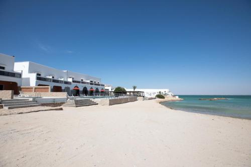 a view of the beach in front of a hotel at Hôtel Calipau Riad Maison d'Hôtes in Dakhla