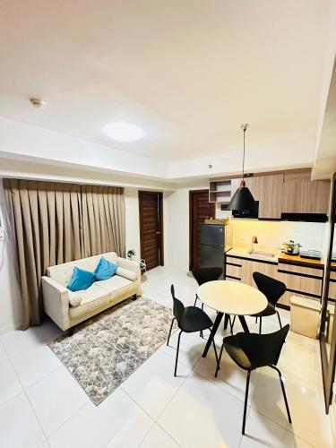 セブシティにあるKR's Cozy 2-Bedroom Unit at Horizons 101のソファとテーブルのあるリビングルーム