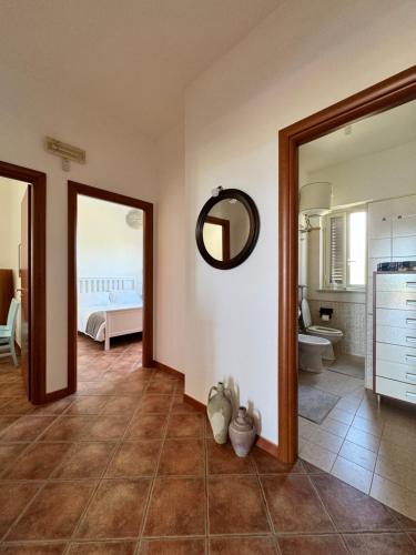 a room with a mirror and a bathroom with a bed at Sun Holidays Home in Marina di Modica