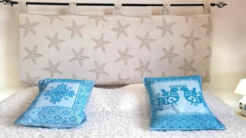 a bed with two blue pillows and a wall with stars at Mistral in Capo Testa