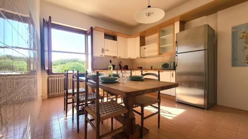 a kitchen with a wooden table and a refrigerator at Mistral in Capo Testa