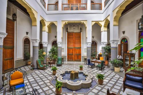 a lobby of a building with a table and chairs at Ryad Mabrouka in Fès