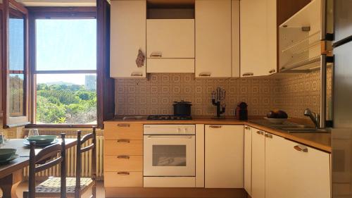 a kitchen with white cabinets and a table and a window at Mistral in Capo Testa