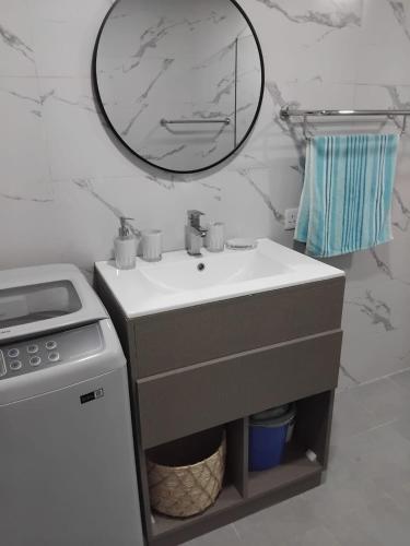 a bathroom with a sink and a mirror on the wall at Seaside Escape Apartment in Flic-en-Flac