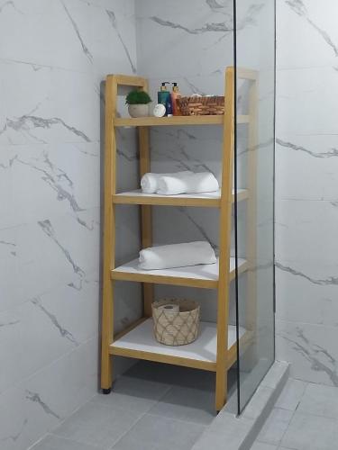 a wooden shelf with towels on it in a bathroom at Seaside Escape Apartment in Flic-en-Flac