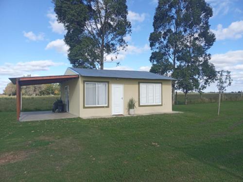 a tiny house with a porch in a field at La Leontina in Villa Elisa