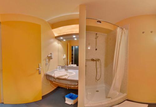 a bathroom with a shower and a sink at Hotel Restaurant De La Canner in Kédange-sur-Canner