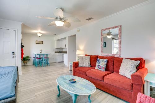 a living room with a red couch and a table at Walk to Pier St Augustine Beach Condo with Balcony! in Saint Augustine Beach