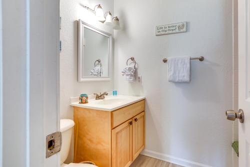 a bathroom with a sink and a toilet and a mirror at Walk to Pier St Augustine Beach Condo with Balcony! in Saint Augustine Beach