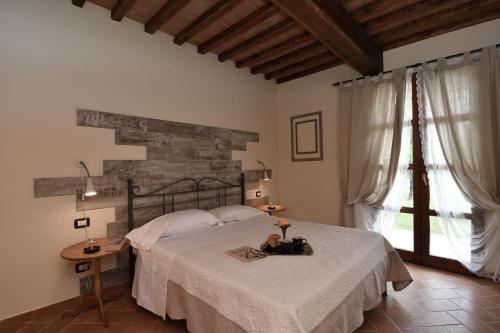 1 dormitorio con cama y ventana grande en Mimosa, en Peccioli