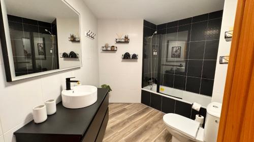 a black and white bathroom with a sink and a shower at Exclusive Lerma - Smart TV de 75", Netflix y Parking Gratis in Lerma