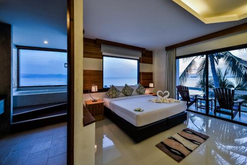 a bedroom with a bed with a view of the ocean at Neptune's Villa in Haad Rin