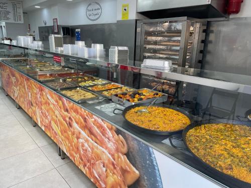 una línea de buffet con muchos tipos diferentes de comida en Apartamentos Bulevar en Valencia